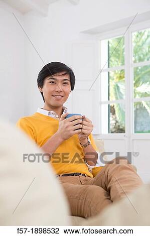 Young Asian man drinking tea View Large Photo Image Stock Image - Young Asian man drinking tea. Fotosearch