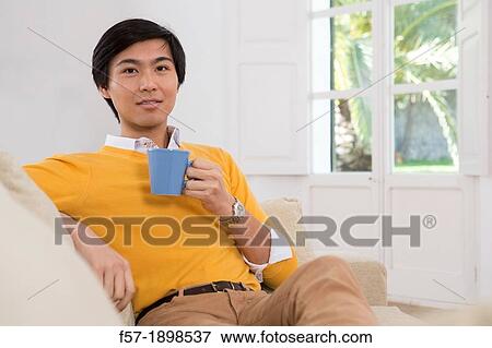 Young Asian man drinking tea View Large Photo Image Stock Photo - Young Asian man drinking tea. Fotosearch
