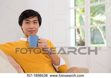 Young Asian man drinking tea View Large Photo Image Stock Photo - Young Asian man drinking tea. Fotosearch