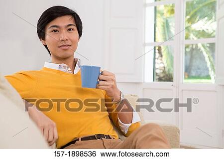 Young Asian man drinking tea View Large Photo Image Stock Photograph - Young Asian man drinking tea. Fotosearch