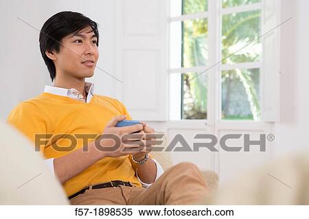 Young Asian man drinking tea View Large Photo Image Stock Photography - Young Asian man drinking tea. Fotosearch