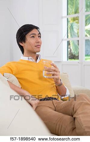 Stock Image - Young Asian man drinking water. Fotosearch
