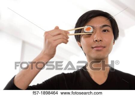 Young Asian man eating sushi View Large Photo Image Picture - Young Asian man eating sushi. Fotosearch