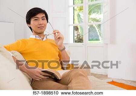 Young Asian man studying a foreign language book View Large Photo Image Stock Image - Young Asian man studying a foreign language book. Fotosearch