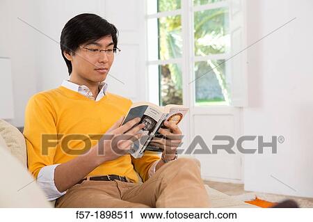 Young Asian man studying a foreign language book View Large Photo Image Stock Image - Young Asian man studying a foreign language book. Fotosearch