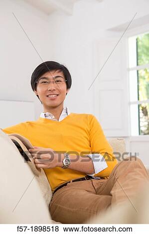 Young Asian man studying a foreign language book View Large Photo Image Stock Photo - Young Asian man studying a foreign language book. Fotosearch