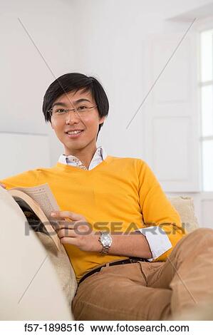 Stock Photograph - Young Asian man studying a foreign language book. Fotosearch