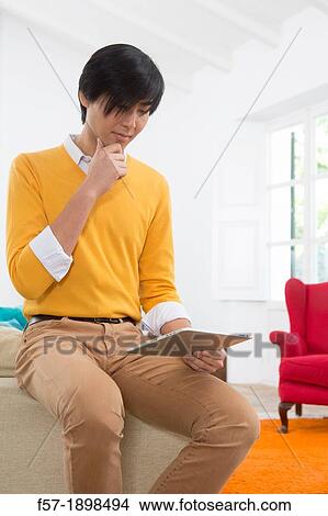 Young Asian man using his Tablet computer View Large Photo Image Picture - Young Asian man using his Tablet computer. Fotosearch