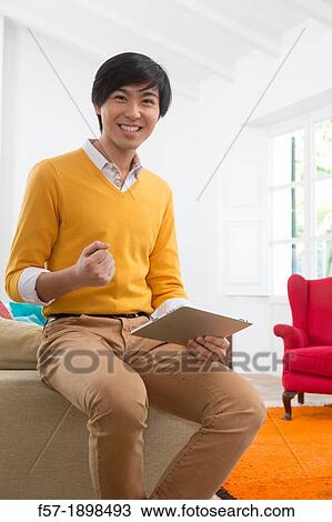 Young Asian man using his Tablet computer View Large Photo Image Stock Image - Young Asian man using his Tablet computer. Fotosearch