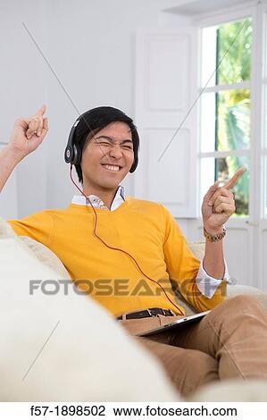 Young Asian man using his Tablet computer View Large Photo Image Stock Image - Young Asian man using his Tablet computer. Fotosearch