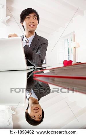 Young Asian man working on his laptop computer View Large Photo Image Stock Image - Young Asian man working on his laptop computer. Fotosearch