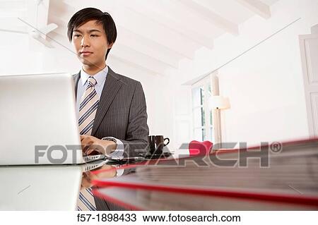 Young Asian man working on his laptop computer View Large Photo Image Stock Image - Young Asian man working on his laptop computer. Fotosearch