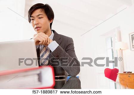 Young Asian man working on his laptop computer View Large Photo Image Stock Photo - Young Asian man working on his laptop computer. Fotosearch