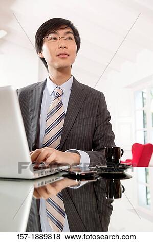 Young Asian man working on his laptop computer View Large Photo Image Stock Photo - Young Asian man working on his laptop computer. Fotosearch