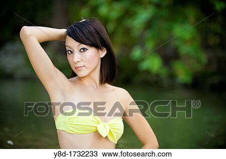 Stock Image - Young Asian Woman in bikini, 20 years old, Korean Ethnicity, posing at the Frio River near Leakey, Texas, USA. Fotosearch