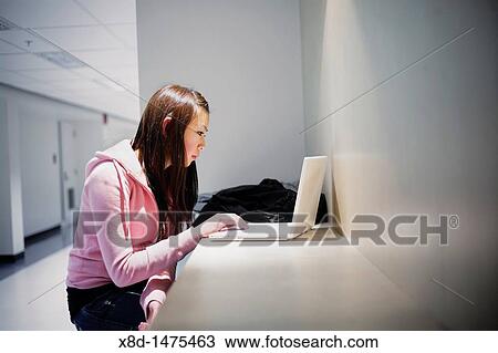 Young Asian woman using her laptop computer in school hallway. View Large Photo Image Stock Image - Young Asian woman using her laptop computer in school hallway.. Fotosearch