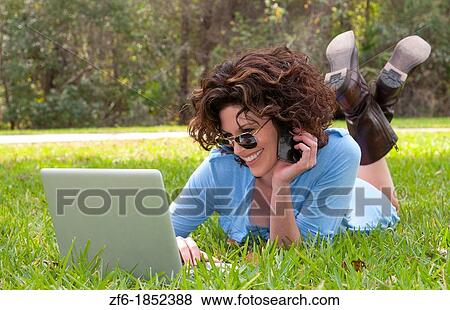 Young attractive woamn age 25 in front of home in yard emailing and talking on cell to friends with sunglasses and modern look View Large Photo Image Stock Photo - Young attractive woamn age 25 in front of home in yard emailing and talking on cell to friends with sunglasses and modern look. Fotosearch
