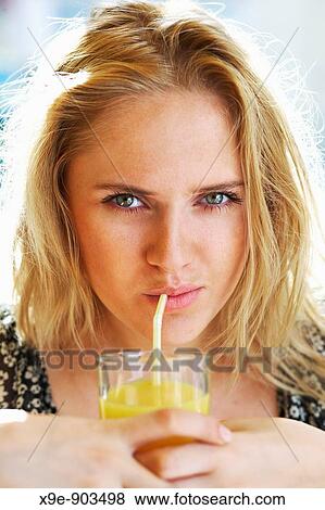 Young attractive woman with a glass of orange juice View Large Photo Image Stock Photo - Young attractive woman with a glass of orange juice. Fotosearch