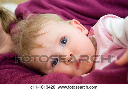 young baby girl 5 five months old resting quietly in mothers arms on bed with big bright eyes looking directly at camera View Large Photo Image Stock Photo - young baby girl 5 five months old resting quietly in mothers arms on bed with big bright eyes looking directly at camera. Fotosearch