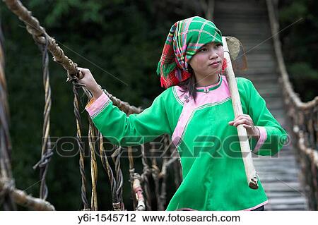 Young barefoot Zay woman with hoe crosses traditional bamboo and rattan bridge Ta Van village near Sapa north Vietnam View Large Photo Image Stock Image - Young barefoot Zay woman with hoe crosses traditional bamboo and rattan bridge Ta Van village near Sapa north Vietnam. Fotosearch
