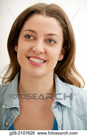 Young beautiful Happy and smiling woman in a blue jeans shirt View Large Photo Image Stock Photograph - Young beautiful Happy and smiling woman in a blue jeans shirt. Fotosearch
