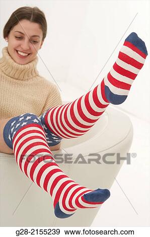 young beautiful happy woman, bouncing upon a white leather armchair, with funny stars and stripes knee high socks View Large Photo Image Stock Photo - young beautiful happy woman, bouncing upon a white leather armchair, with funny stars and stripes knee high socks. Fotosearch