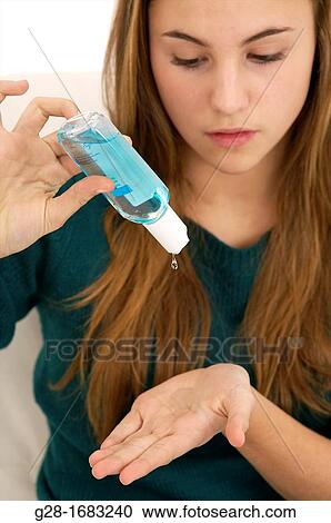 young beautiful teenage girl, pouring blue disinfectant on her hand View Large Photo Image Stock Image - young beautiful teenage girl, pouring blue disinfectant on her hand. Fotosearch