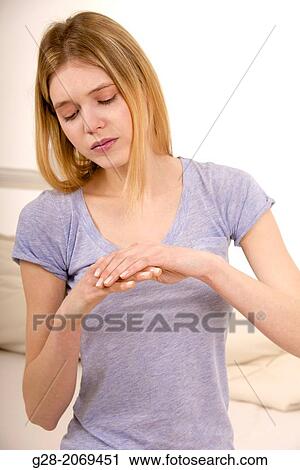 Young beautiful woman holding her stiff painful fingers View Large Photo Image Stock Image - Young beautiful woman holding her stiff painful fingers. Fotosearch