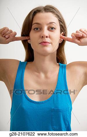 Young beautiful woman in a blue top, stopping both ears with her fingers View Large Photo Image Stock Image - Young beautiful woman in a blue top, stopping both ears with her fingers. Fotosearch