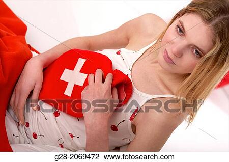 Young beautiful woman in bed, holding a red and white hot water bottle View Large Photo Image Stock Image - Young beautiful woman in bed, holding a red and white hot water bottle. Fotosearch