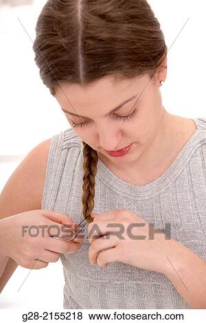 Young beautiful woman in grey plaiting her long hair View Large Photo Image Stock Photo - Young beautiful woman in grey plaiting her long hair. Fotosearch