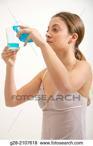 Young beautiful woman in pink underwear, using blue mouthwash View Large Photo Image Stock Photo - Young beautiful woman in pink underwear, using blue mouthwash. Fotosearch