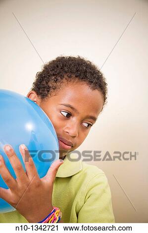 Young black boy holding a balloon View Large Photo Image Stock Image - Young black boy holding a balloon. Fotosearch