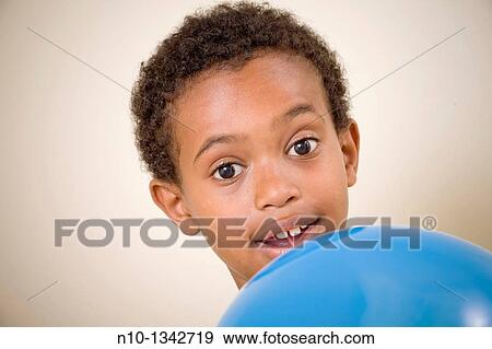 Young black boy holding a balloon View Large Photo Image Stock Photo - Young black boy holding a balloon. Fotosearch