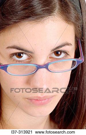 Young black-haired girl looking at the camera over her blue eyeglasses View Large Photo Image Stock Image - Young black-haired girl looking at the camera over her blue eyeglasses. Fotosearch