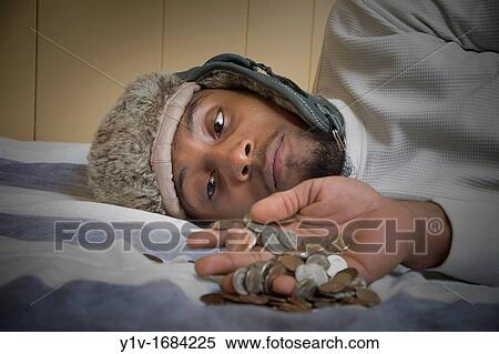 Stock Photography - Young black man with United States coins. Fotosearch