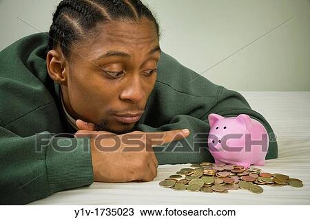 Young black man with United States coins and a piggy bank View Large Photo Image Stock Image - Young black man with United States coins and a piggy bank. Fotosearch