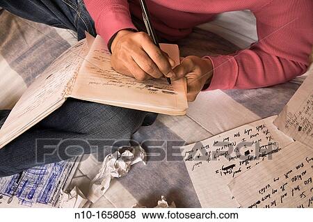 Stock Photo - Young black man writing in his notebook. Fotosearch