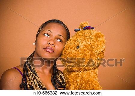 Young black woman holding a stuffed animal. View Large Photo Image Stock Image - Young black woman holding a stuffed animal.. Fotosearch