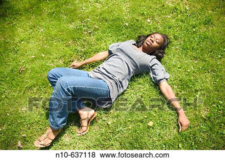 Young black woman lying on the ground, posing View Large Photo Image Stock Photo - Young black woman lying on the ground, posing. Fotosearch