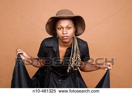 Young black woman, wearing a hat, holding up the corners of her dress View Large Photo Image Stock Photography - Young black woman, wearing a hat, holding up the corners of her dress. Fotosearch
