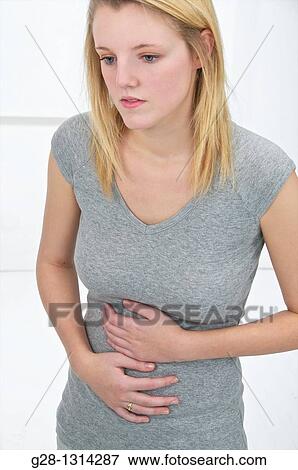 Young blond attractive woman with long hair holding her stomach with both hands for pain View Large Photo Image Stock Photo - Young blond attractive woman with long hair holding her stomach with both hands for pain. Fotosearch
