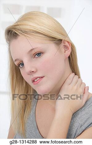 Young blond attractive woman with long hair holding her neck for pain or scratching herself View Large Photo Image Stock Photo - Young blond attractive woman with long hair holding her neck for pain or scratching herself. Fotosearch