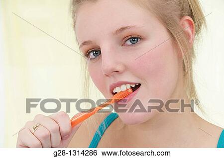 Young blond attractive woman with long hair brushing her hair with a tooth brush, in turquoise blue View Large Photo Image Stock Photograph - Young blond attractive woman with long hair brushing her hair with a tooth brush, in turquoise blue. Fotosearch