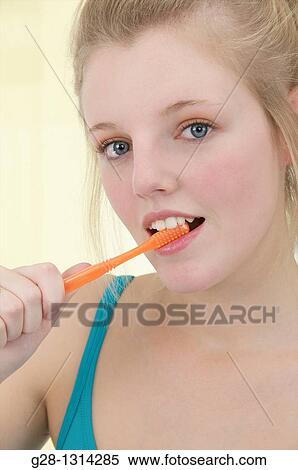 Young blond attractive woman with long hair brushing her hair with a tooth brush, in turquoise blue View Large Photo Image Stock Photography - Young blond attractive woman with long hair brushing her hair with a tooth brush, in turquoise blue. Fotosearch