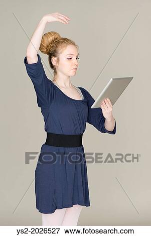 Young blond female teenager in ballet dress holding a tablet pc. View Large Photo Image Stock Photo - Young blond female teenager in ballet dress holding a tablet pc.. Fotosearch