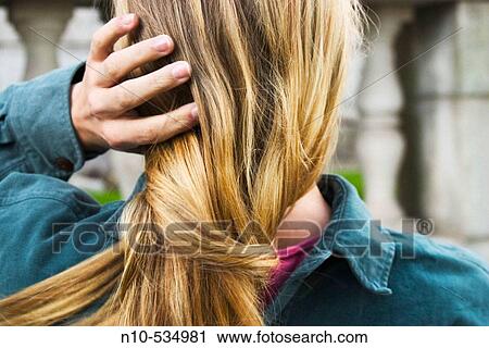 Young blond woman fixing her hair View Large Photo Image Stock Image - Young blond woman fixing her hair. Fotosearch