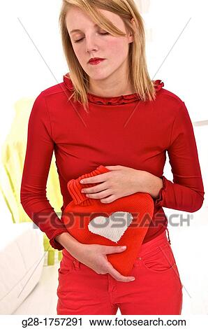 Young blond woman holding a red heart shaped hot water bottle View Large Photo Image Stock Image - Young blond woman holding a red heart shaped hot water bottle. Fotosearch