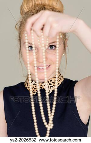Young blond woman looking at pearl necklace. View Large Photo Image Stock Image - Young blond woman looking at pearl necklace.. Fotosearch