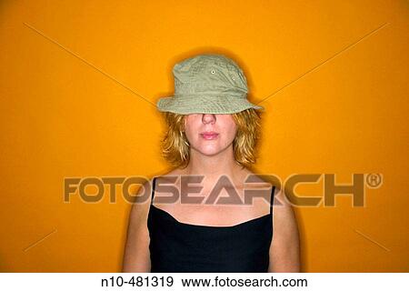 Young blond woman wearing a hat that covers her eyes View Large Photo Image Stock Photo - Young blond woman wearing a hat that covers her eyes. Fotosearch
